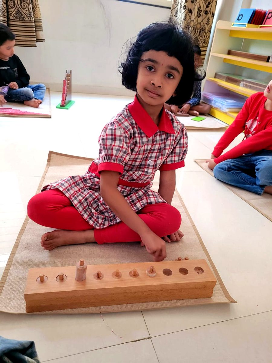 Child working with Montessori knobbed cylinders
